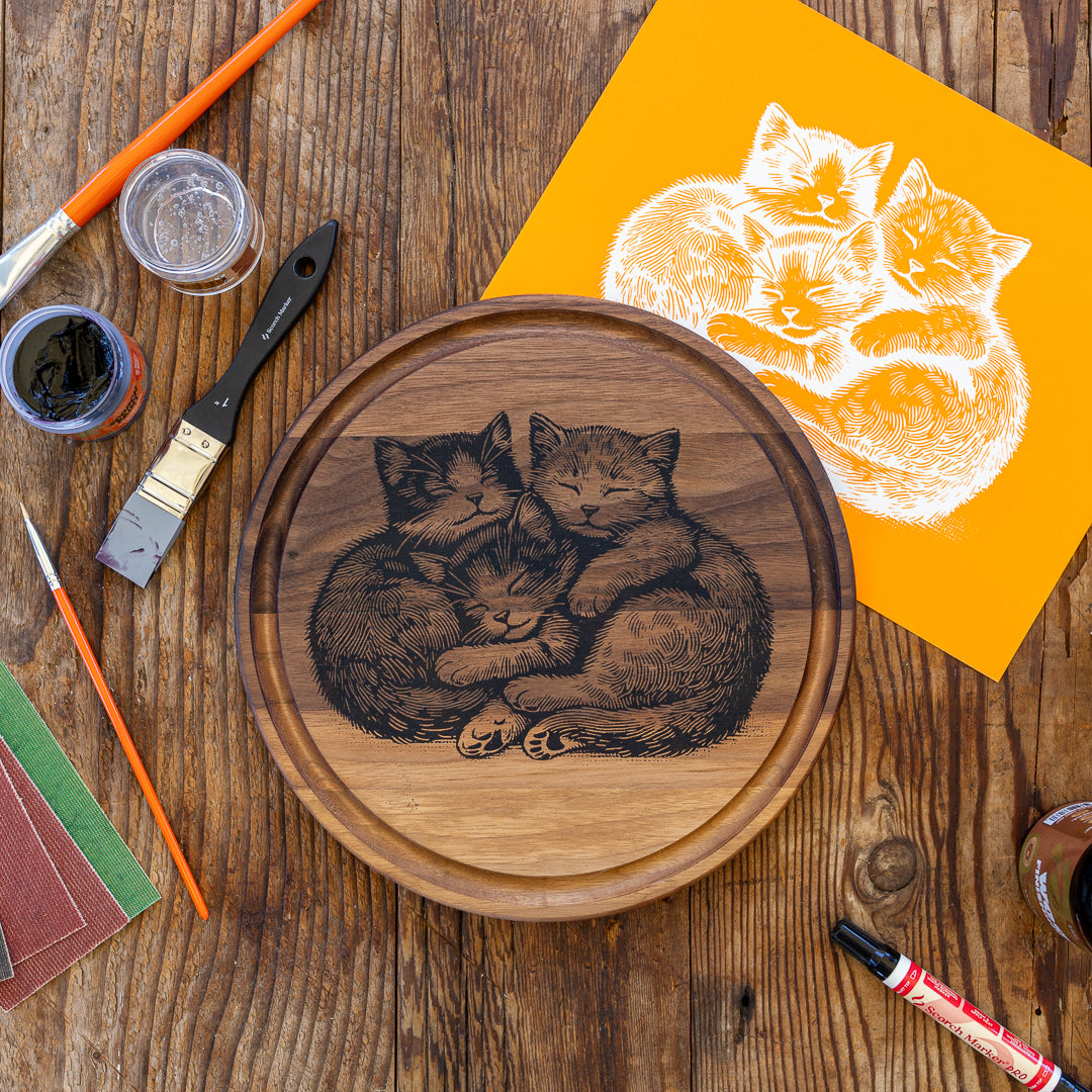 A cutting board burned with Scorch Paint and a mesh stencil, with the Scorch Marker kit beside it